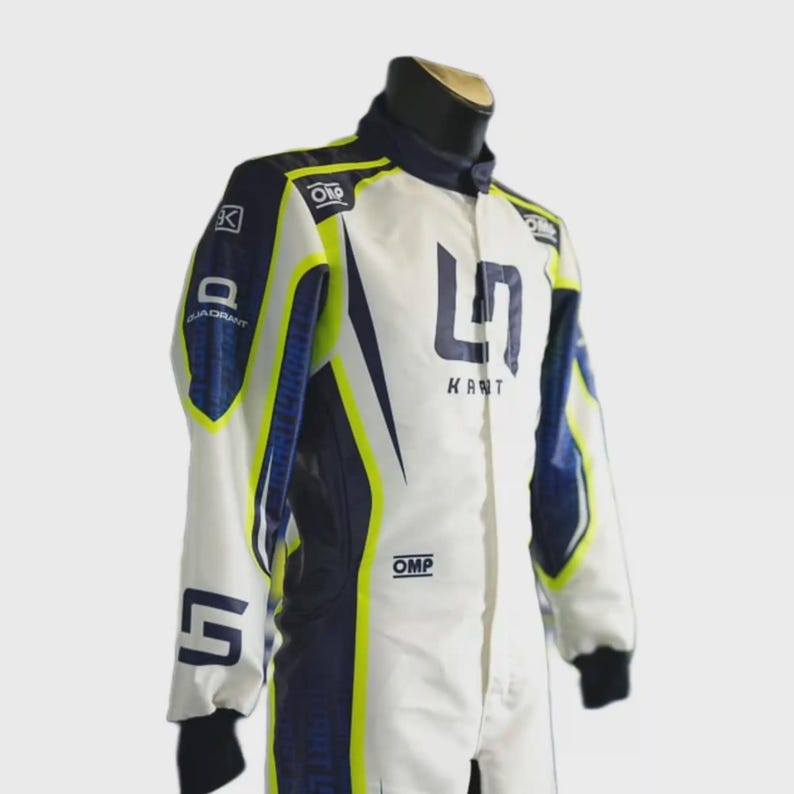 May include: White racing suit with navy blue and neon yellow accents. Features the text "KANT" and the number "5". Includes the "OMP" and "QUADRANT" logos. The suit has a high collar and black cuffs.