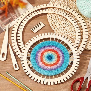 May include: Two circular wooden weaving looms with notched edges, one containing a multi-colored circular yarn weaving. Includes two wooden weaving needles, a small wooden comb, two metal crochet hooks, and a pair of metal scissors with red handles.