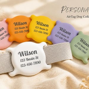 May include: A collection of six silicone AirTag dog collar holders in white, pink, orange, yellow, purple, and green. Each holder features the printed text Wilson, 123 Basin St, and 123-456-7890. One white holder is attached to a beige fabric strap.