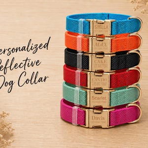 May include: A stack of six reflective dog collars in blue, orange, black, red, teal, and magenta. Each collar features a gold-tone metal buckle engraved with a name and phone number. The text Personalized Reflective Dog Collar is visible.