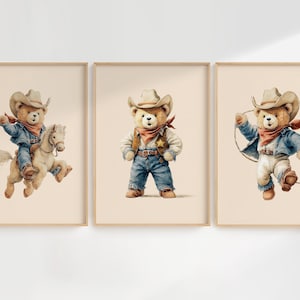 May include: Set of three framed prints featuring watercolor illustrations of teddy bears dressed as cowboys. One bear rides a horse, another stands, and the third twirls a lasso. Each bear wears a cowboy hat and denim.