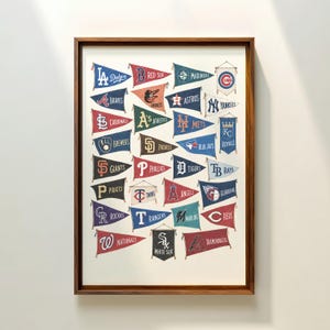 Peut inclure: Une impression d'art encadrée présentant une collection de fanions d'équipes de la Major League Baseball. Chaque fanion affiche le logo et le nom d'une équipe, disposés en grille sur un fond clair dans un cadre en bois foncé.