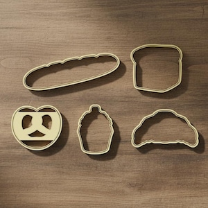 Puede incluir: Un juego de tres tazas de cerámica con un acabado mate moteado. Las tazas son de color crema, gris claro y gris oscuro. Cada taza tiene un diseño simple y minimalista y un asa redondeada.
