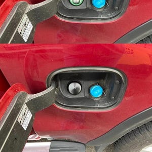 May include: A white ceramic mug with a black handle and the text "But First, Coffee" in a black, handwritten-style font. The mug is on a white surface.