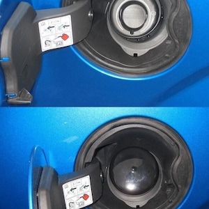 May include: Close-up of a blue car's fuel door, open and closed. The fuel door is black and has a label with instructions. The fuel filler neck is visible, with "Easy Fuel" printed on the cap.