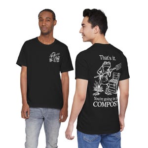 May include: Black t-shirts with a white graphic of a frog holding a pitchfork. The front of the shirt has a small frog graphic. The back of the shirt has the text "That's it. You're going in the COMPOST."