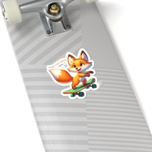 Peut inclure: Un autocollant représentant un renard de dessin animé sur un skateboard. Le renard est orange et blanc, et le skateboard est vert. Le texte "Ride the Grind" est au-dessus du renard. L'autocollant est sur une surface à rayures grises et blanches.