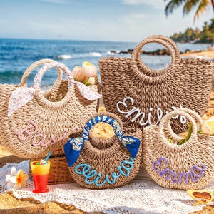 May include: Four woven straw tote bags with round handles, each featuring a custom name in cursive yarn lettering. The bags are decorated with colorful patterned fabric ribbons tied to the handles and include small artificial flowers tucked inside.