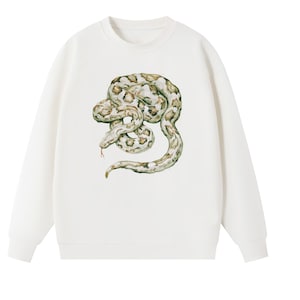 Op de afbeelding: Een crèmekleurig sweatshirt met ronde hals en een gedetailleerde illustratie van een opgerolde slang op de voorzijde. De slang is afgebeeld in bruin-, beige- en groentinten met een zichtbare rode tong, gecentreerd op de borst van het kledingstuk.