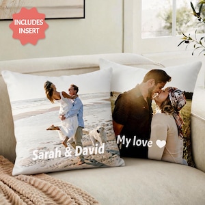 May include: Two white throw pillows with custom photos. One pillow features a couple on a beach with the text "Sarah & David." The other pillow shows a couple kissing with the text "My love" and a heart symbol.