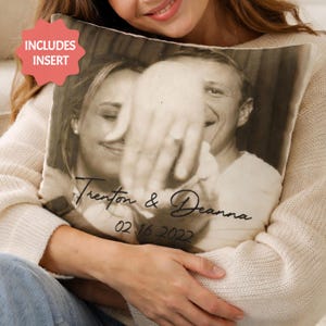 May include: A square pillow with a black and white photograph of a couple, with the names "Trenton & Deanna" and the date "02.16.2022" printed on it. The pillow includes an insert.
