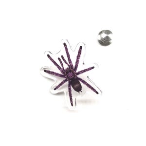 Pode incluir: Um alfinete de acrílico transparente com uma ilustração detalhada de uma aranha tarântula roxa. A aranha tem um corpo escuro e longas pernas de aranha. Um pino de prata está preso. Este acessório com tema de insetos é perfeito.