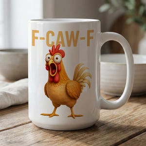 May include: A white ceramic mug featuring a cartoon illustration of a surprised brown chicken with a red comb and wattle. Above the chicken, the text F-CAW-F is printed in bold, yellow, sans-serif capital letters. The mug has a handle on the right side.