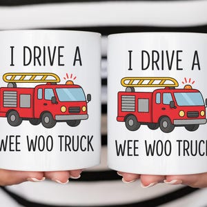 May include: Two white ceramic mugs with the text "I DRIVE A WEE WOO TRUCK" and a red fire truck graphic. The fire truck has a yellow ladder on top and is set against a white background.