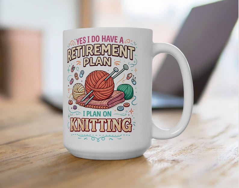 Op de afbeelding: Witte keramische mok met de tekst "YES I DO HAVE A RETIREMENT PLAN I PLAN ON KNITTING". De mok heeft illustraties van garen, breinaalden en knopen. De mok staat op een houten oppervlak.