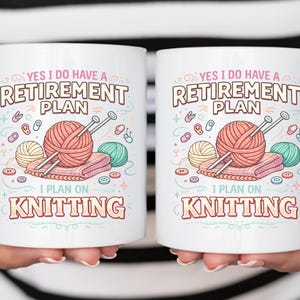 Op de afbeelding: Twee witte keramische mokken met de tekst "YES I DO HAVE A RETIREMENT PLAN I PLAN ON KNITTING". Elke mok heeft een afbeelding van garen, breinaalden en andere brei-elementen in roze, groen en geel.