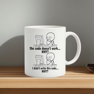 Può includere: Tazza in ceramica bianca con grafica in bianco e nero di un personaggio davanti a un computer, con il testo "the code doesn't work... WHY?" e "I didn't write this code... WHY?"