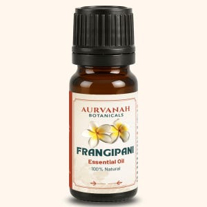 May include: A brown glass bottle of Frangipani essential oil with a black cap. The label features the text "AURVANAH BOTANICALS", "FRANGIPANI Essential Oil 100% Natural", and illustrations of white and yellow flowers.
