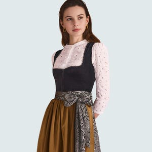 May include: A traditional German dirndl dress. The dress features a black bodice, a white blouse with eyelet details, and a mustard-coloured skirt. A decorative patterned sash is tied around the waist, adding a touch of elegance to the outfit.