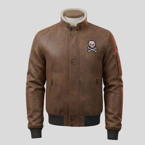 Può includere: Giacca bomber in pelle marrone con colletto in ecopelliccia bianca. La giacca presenta una toppa con teschio e ossa incrociate e un motivo geometrico sulle maniche. Ha un orlo e polsini a coste neri.