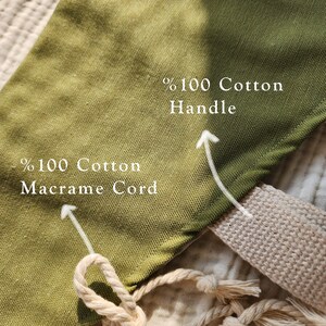 Puede incluir: Una superficie de tela verde oliva con etiquetas de texto blancas. Una etiqueta se&ntilde;ala un cord&oacute;n de macram&eacute; beige con el texto %100 Cotton Macrame Cord. Otra etiqueta se&ntilde;ala un asa de tela beige con el texto %100 Cotton Handle.