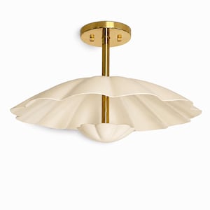 May include: A ceiling light fixture featuring a polished brass finish canopy and central rod. The fixture includes two cream-colored, scalloped, shell-shaped shades, with a larger upper shade and a smaller lower shade attached to the central stem.