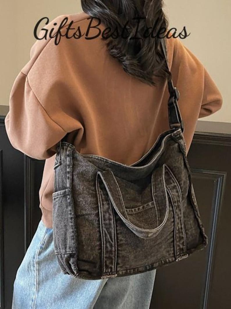 May include: A black denim tote bag with a shoulder strap and two handles. The bag has a pocket on the front and is worn over the shoulder. The text "Gifts Best Ideas" is visible in the image.