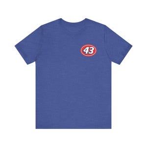 May include: Blue short-sleeve t-shirt with a small, oval logo on the chest. The logo features the number 43 in white, set against a red background with a white border. The shirt is made of a soft material.