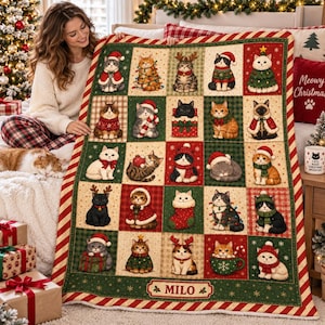 May include: A rectangular throw blanket featuring a grid of twenty-five squares, each displaying a different cat in a Christmas-themed outfit or setting. The blanket has a red and white striped border and the name MILO printed at the bottom.