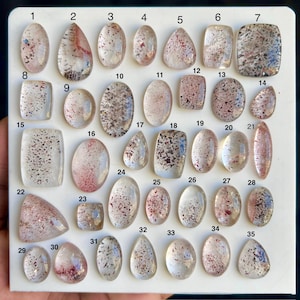 以下が含まれることがあります： 赤と茶色の鉱物を含む、35個の透明な水晶の宝石のコレクション。 宝石は、楕円形、涙滴型、長方形など、さまざまな形をしています。 宝石には1から35までの番号が付けられています。