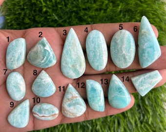 Peut inclure: Une collection de quatorze pierres précieuses d'amazonite polies de formes variées, dont des gouttes, des ovales et des triangles. Les pierres présentent une couleur bleu-vert clair avec des veines blanches. Les pierres sont numérotées de 1 à 14.