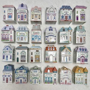 May include: A set of three ceramic mugs with a speckled, matte finish. The mugs are in shades of cream, light gray, and dark gray. Each mug has a simple, minimalist design, perfect for coffee or tea.