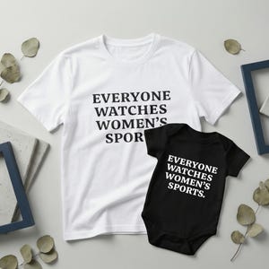 Könnte beinhalten: Ein weißes T-Shirt und ein schwarzer Baby-Body mit dem Text "EVERYONE WATCHES WOMEN'S SPORTS" in fetten, schwarzen und weißen Buchstaben. Das T-Shirt ist kurzärmlig und der Body ist kurzärmlig.