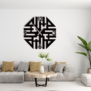 Puede incluir: Reloj de pared geométrico negro con manecillas y números plateados en el 12, 3, 6 y 9. El reloj tiene un diseño único y abierto y está montado en una pared blanca. El diámetro del reloj es de aproximadamente 50 cm.