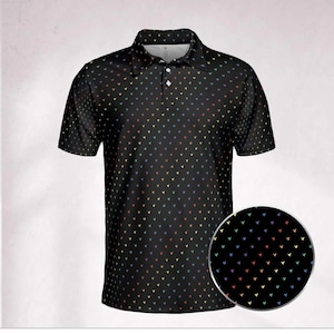 May include: Black polo shirt with a repeating pattern of small, multicolored arrow shapes. The shirt has a collared neckline, short sleeves, and a three-button placket. A circular inset shows a close-up of the pattern.