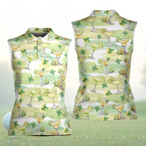 May include: Sleeveless golf shirt featuring a repeating watercolor pattern of margaritas, limes, and mint leaves on a white and green striped background. The shirt has a collared neckline with three buttons.