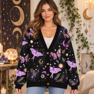 May include: A black V-neck cardigan featuring a repeating pattern of purple moths, butterflies, golden suns, crescent moons, and stars. The long-sleeved knit garment has a solid black button-down front placket with four visible brown buttons.