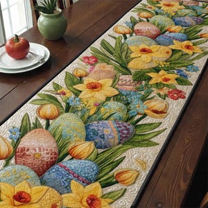 May include: An Easter-themed table runner with embroidered eggs and daffodils in yellow, blue, and pink. The rectangular runner is displayed on a dark wooden table, adding a festive touch to the dining area. The runner measures approximately 150 cm in length.
