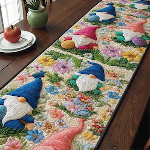 Może przedstawiać: Pikowany bieżnik na stół z gnomami w niebieskich i różowych czapkach i białych brodach. Bieżnik jest ozdobiony kolorowymi kwiatami w odcieniach różu, żółci i błękitu, tworząc wzór o tematyce ogrodowej.