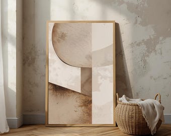 May include: Abstract art print in a wooden frame. The artwork features geometric shapes in shades of beige, brown, and cream. A woven basket with a blanket sits beside the framed art, adding a touch of texture to the neutral-toned scene.