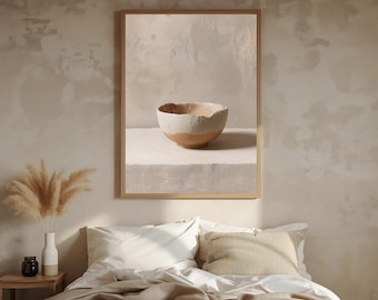 May include: A framed print featuring a still life of a textured, two-toned bowl. The bowl is light-colored with a brown base, set against a neutral background. The artwork is displayed above a bed with white bedding and a decorative pillow.
