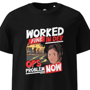 Może przedstawiać: Czarna koszulka z graficznym wzorem. Wzór przedstawia tekst "WORKED FINE IN DEV" nad kreskówkową ilustracją płonącego budynku i osoby. Poniżej znajduje się tekst "OPS PROBLEM NOW".
