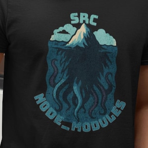 Op de afbeelding: Zwart t-shirt met een grafisch ontwerp met een berg, wolken en tentakels, met de tekst "SRC NODE-MODULES" in blauw en wit. Het t-shirt wordt gedragen door een persoon in een blauwe jeans.