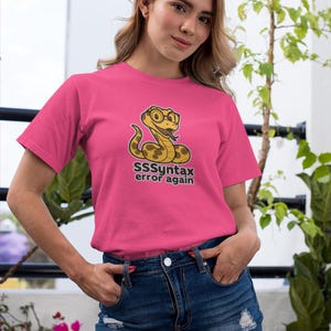 Unisex cotton t-shirt with cartoon python snake wearing glasses and text “SSSyntax Error Again”, python humor shirt for programmers