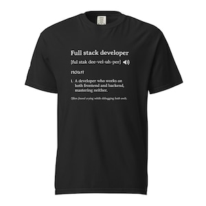 Op de afbeelding: Zwart t-shirt met witte tekst die "Full stack developer" definieert als een zelfstandig naamwoord. De definitie bevat de fonetische uitspraak en een humoristische beschrijving van de rol, inclusief de zin "Often found crying while debugging both ends."