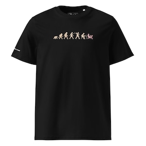 Könnte beinhalten: Schwarzes T-Shirt mit Rundhalsausschnitt und beigem Aufdruck, der die Evolution des Menschen darstellt. Die Grafik zeigt die Stadien der menschlichen Evolution, die mit einer Person am Computer endet. Das Shirt hat ein kleines Logo auf dem Ärmel.