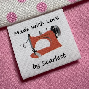 May include: White fabric label with the text "Made with Love by Scarlett" and a red sewing machine illustration.