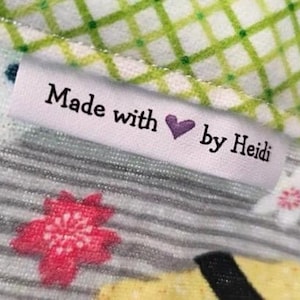 May include: A white label with black text that reads "Made with ♥ by Heidi" on a colorful fabric background.