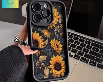 May include: Black phone case with a sunflower design. The case has a dark background with yellow sunflowers and blue leaves. The case has a black border and a camera cutout.