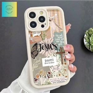 May include: Cream-coloured phone case with a collage design. It features the word "Jesus", a butterfly, flowers, and religious quotes. The case has a protective bumper and a camera cutout.